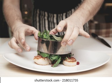 Chef is cooking appetizer with sea scallops and salad mix, toned image - Powered by Shutterstock