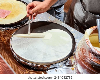 Chef cooking crepes at a street food stall. - Powered by Shutterstock