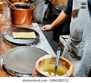 Chef cooking crepes at a street food stall. - Powered by Shutterstock