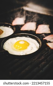 Chef Cooking Eggs And Bacon In Pan On Grill In Kitchen