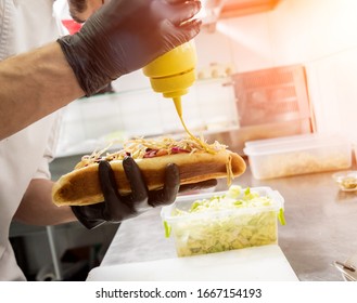 The chef cooking hot dog on a grill. Restaurant. - Powered by Shutterstock