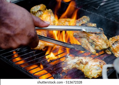 Chef Cooking Jerk Barbecue BBQ Chicken On The Grill Hand Turning Food