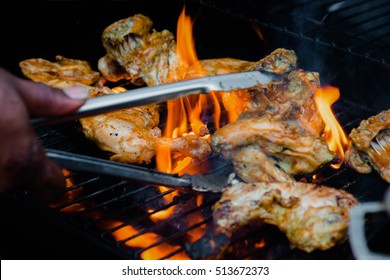 Chef cooking jerk barbecue BBQ chicken on the grill hand turning food