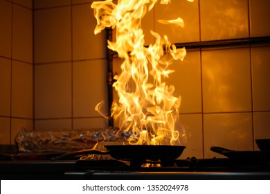 The chef cooking and makes a fire in a pan. Cooking with fire. Crown food.Flame on kitchen