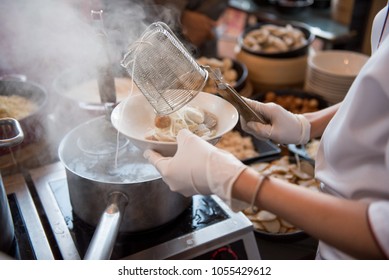 Chef cooking noodle with shrimp and fish ball in local restaurant, Thailand street food. making noodle in Traditional Asian Food. Chinese noodle ripen and ball with spoon dumpling in hot boiled soup - Powered by Shutterstock