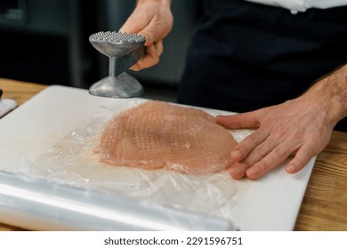 chef cooking professional kitchen pounding chicken fillet with meat mallet healthy food concept