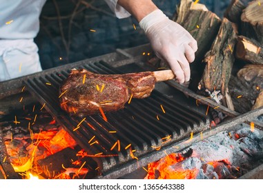 Chef Cooking Steak. Cook Turns The Meat On The Fire