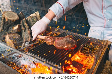 Chef Cooking Steak. Cook Turns The Meat On The Fire