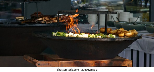 chef cooks broccoli, potatoes and meat at street food festival, barbeque. High quality photo