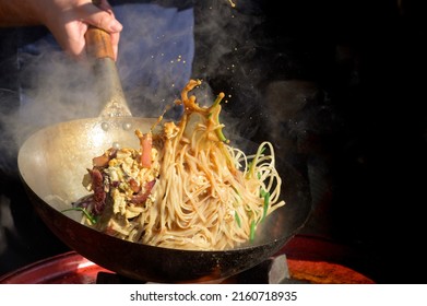 Chef cooks Chinese noodle wok at street food festival - Powered by Shutterstock