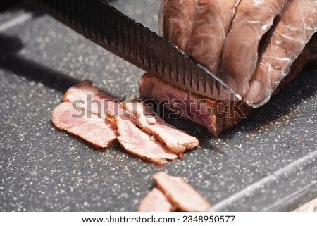 The chef cuts the duck meat into thin slices