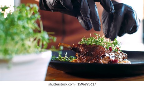 Chef Is Cuts Off A Greens And Adding It On Roasted Duck At Restaurant. The Cook Decorates The Dish Before Serving.