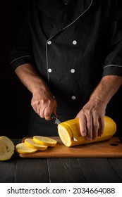 Chef Cuts Ripe Marrow With A Knife. Fried Zucchini Is Great Diet For Breakfast Or Lunch. Work Environment On Kitchen Table Of The Restaurant