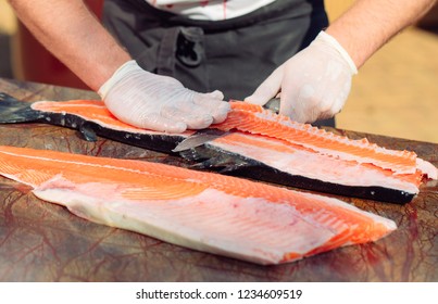 The chef cuts the salmon on the table. - Shutterstock ID 1234609519