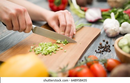 Chef cuts the vegetables into a meal. Preparing dishes. A woman uses a knife and cooks.