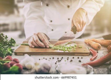 Chef cuts the vegetables into a meal. Preparing dishes. A man uses a knife and cooks. - Shutterstock ID 669987451