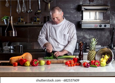 Chef cuts the vegetables into a meal. Preparing dishes. A man uses a knife and cooks