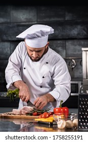 Chef Cutting Beef At Kitchen. Chef In Uniform Cut Steak At Planked. Concentrated Chef Male Cook Meat At Professional Kitchen.