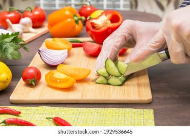 Chef Cutting Cucumber And Different Vegetables For Salad Close Up. Hands In Gloves Cooking Healthy Vegetarian Vegan Diet Food