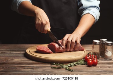 Chef Cutting Fresh Raw Meat On Wooden Board