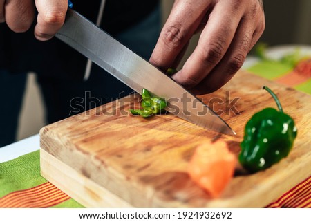 chef cutting habanero on cutting board for mexican sauce