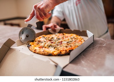 Chef Cutting Pizza For Take Away.