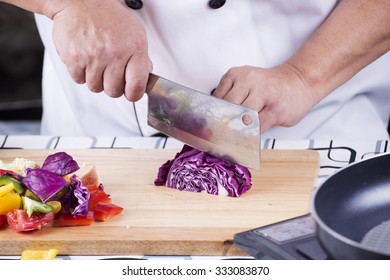 Chef cutting purple cabbage on wooden broad - Powered by Shutterstock