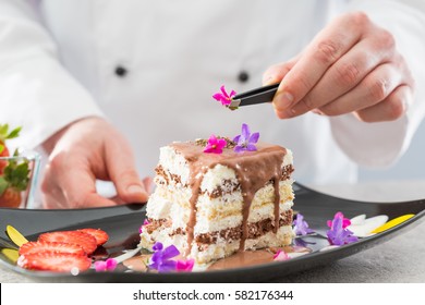 Chef decorate dessert. Decoration of flowers and fruit. Cake with icing. - Powered by Shutterstock