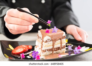 Chef decorate dessert. Decoration of flowers and fruit. Cake with icing. - Powered by Shutterstock