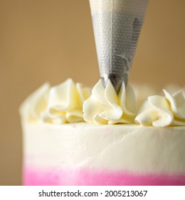 Chef Decorates Cake With Cream Using Pastry Syringe. Close-up Shot. Soft Focus. Copy Space.