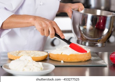 Chef Decorating A Delicious Cake With Cream