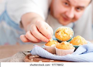 Chef is decorating delicious organic muffins. Almond and cherry cup cakes in natural setting. - Powered by Shutterstock