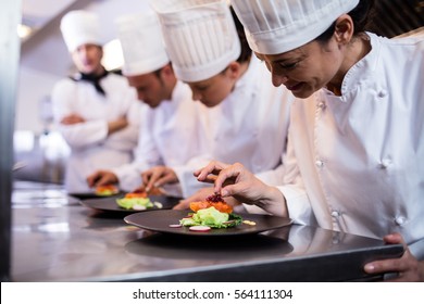 Chef decorating a food plate in the commercial kitchen - Powered by Shutterstock