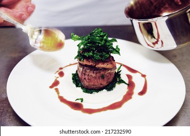 Chef Is Decorating Tenderloin Steak With Sauce, Motion Blur On Spoon, Toned Image