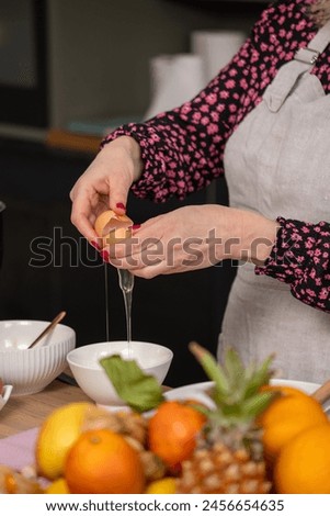 A chef demonstrates the precise art of egg separation, focusing on the egg yolk and white over a bowl, essential for baking recipes. High quality photo
