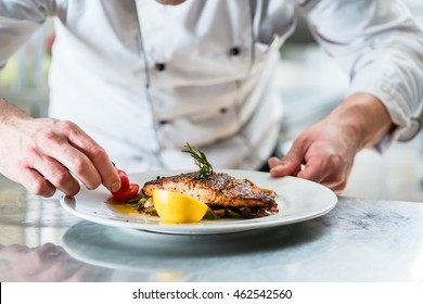 Chef with diligence finishing dish on plate, fish with vegetables - Powered by Shutterstock