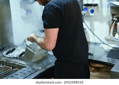 chef drain pasta from professional bolier in kitchen restaurant in Italy - Powered by Shutterstock