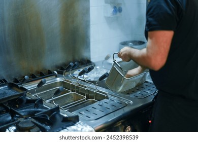 chef drain pasta from professional bolier in kitchen restaurant in Italy - Powered by Shutterstock