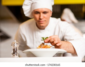 Chef dressed in white uniform decorating pasta salad - Powered by Shutterstock