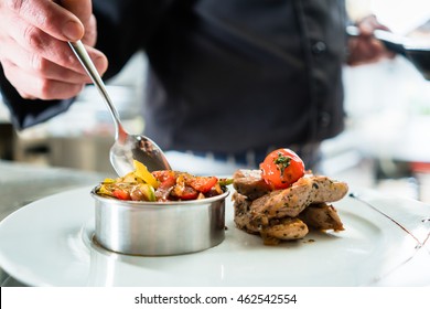 Chef Finishing Food On Plate In Restaurant Or Hotel Kitchen 