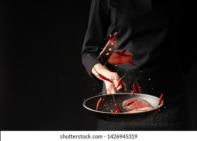 Chef fried fish with small red hot pepper on a griddle against a black background. horizontal photo. sea food. healthy food. oriental cuisine, baner - Shutterstock ID 1426945319