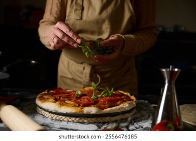 A chef garnishes a freshly baked pizza with basil in a warm, inviting kitchen environment, evoking the essence of homemade cooking and culinary artistry. - Powered by Shutterstock