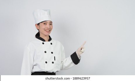 Chef gesturing. Portrait beautiful asian woman cook wearing hat and chef uniform making gesture sign and looking at the camera. Influencer. Cooking class. Copy space. Online food merchant chef.