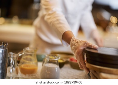 Chef in gloves moving objects on kitchen table