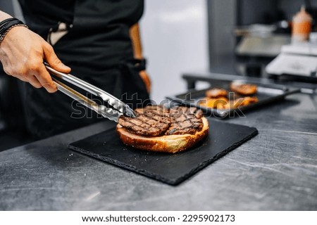 chef hand cooking big large cheese burger on restaurant kitchen. step by step