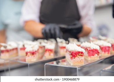 Chef Hand In Patisserie Restaurant Prepares Cakes And Decorates With Chocolate Icing.