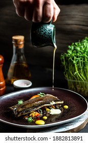 Chef Hands Cooking Fish Dish Roasted Trout, Vegetables And White Creamy Sauce In A Freeze Motion. Vertical Image, Place For Text.