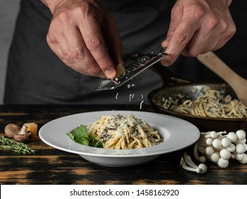 Chef Hands Cooking Italian Pasta Carbonara With Cheese Parmesan And White Creamy Sauce On Wooden Table Background.