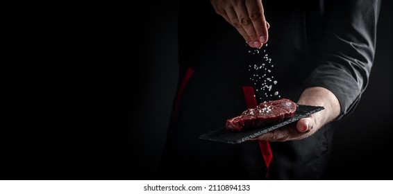 Chef hands cooking meat steak and adding seasoning in a freeze motion. Fresh raw Prime Black Angus beef rump steak. banner, menu recipe. - Shutterstock ID 2110894133