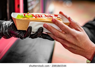 Chef Hands Gives A Hot Dog To Man From Food Truck On Street. Street Food, Fast Food.